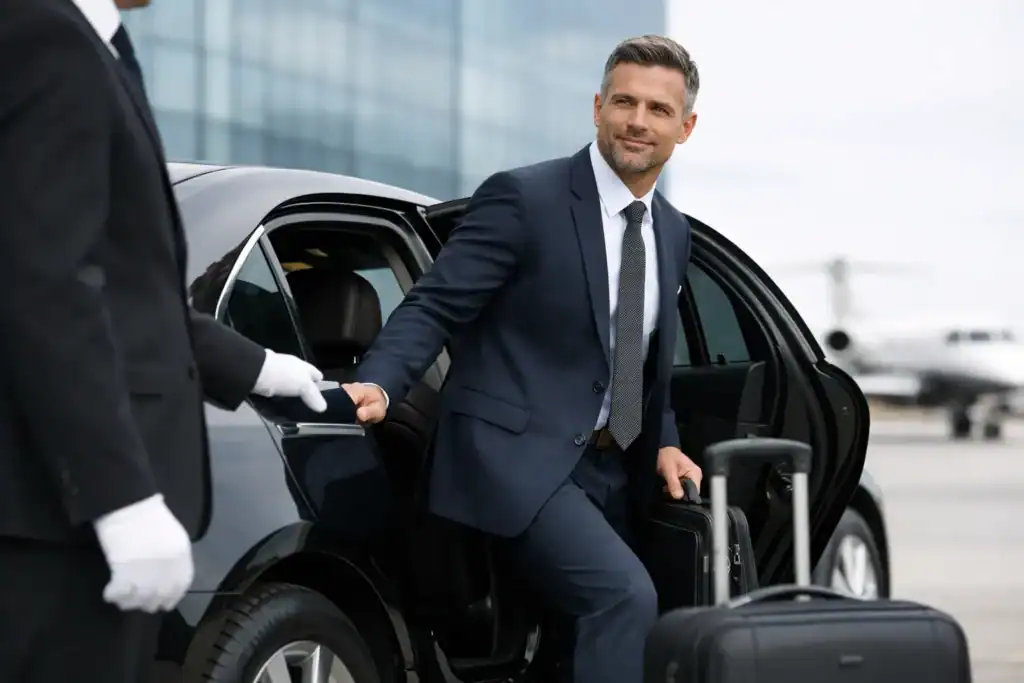 Businessman arriving at Logan Airport in a luxury black SUV for corporate transportation.