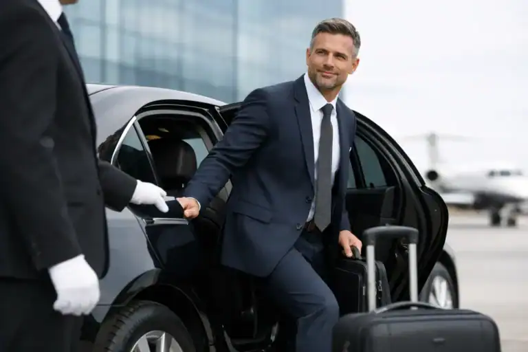 Businessman arriving at Logan Airport in a luxury black SUV for corporate transportation.