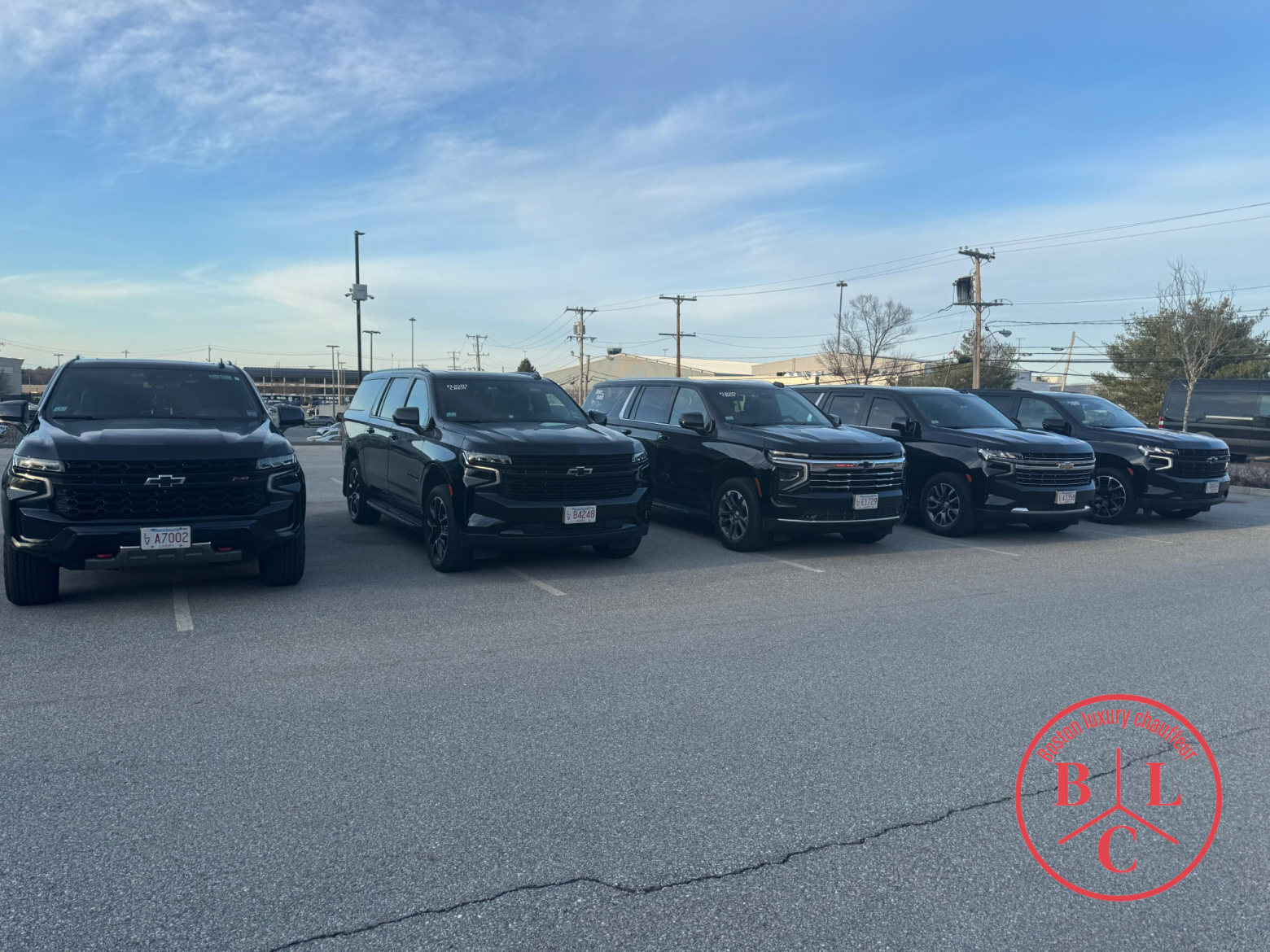 Boston Luxury Chauffeur fleet — five black Chevrolet Suburban SUVs lined up, ready for service