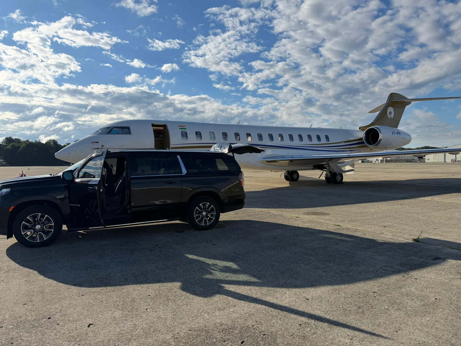 Black Chevrolet Suburban luxury SUV beside private jet on tarmac — Boston Luxury Chauffeur Newark EWR airport transfer service