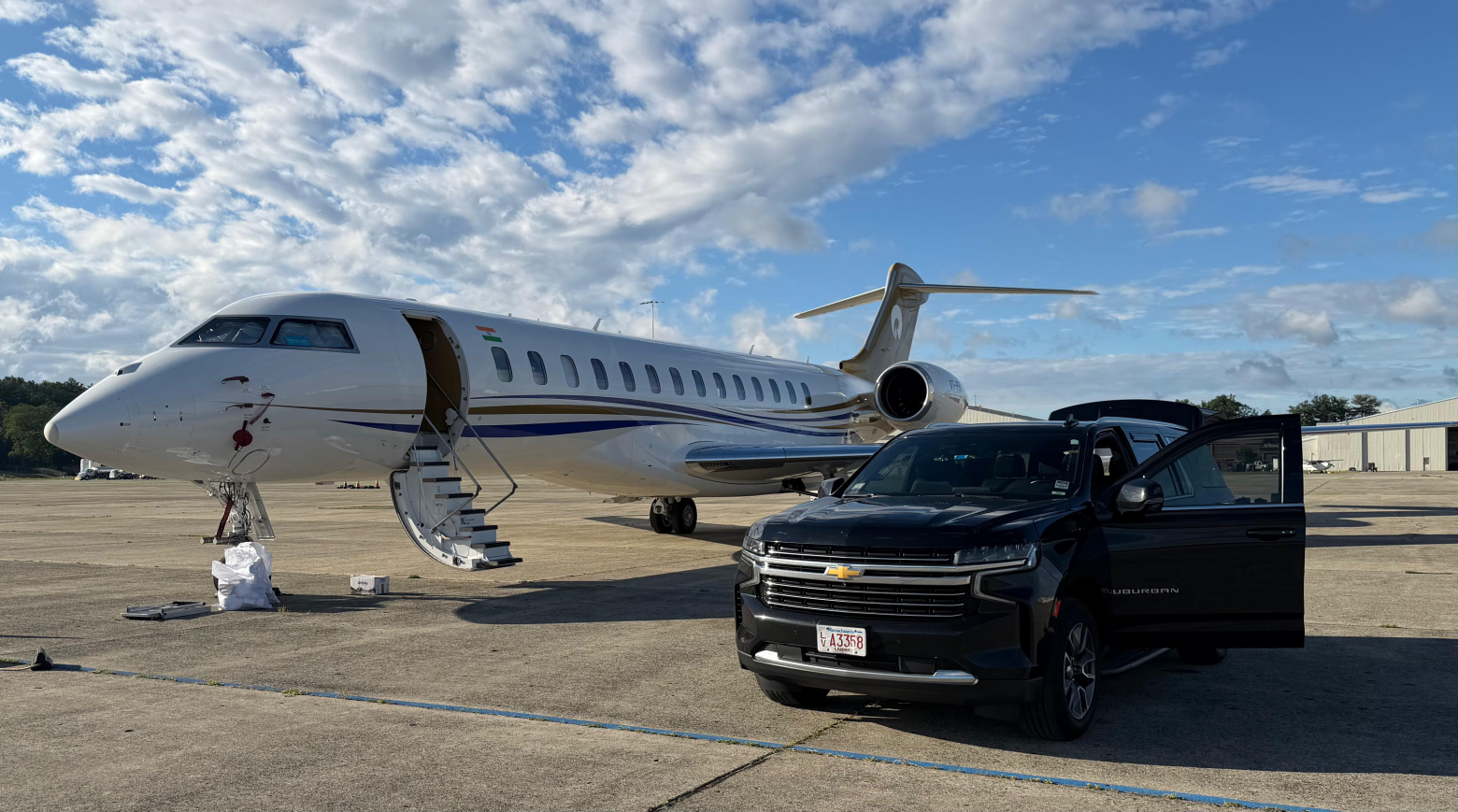 Black Chevrolet Suburban luxury SUV parked beside private jet on tarmac — Boston Luxury Chauffeur airport transfer service