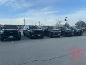 Row of black full-size SUVs parked side by side