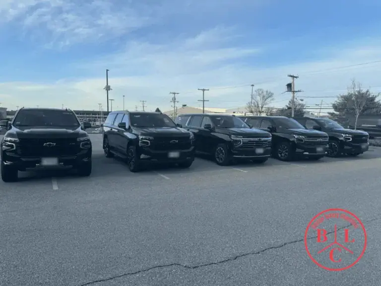 Row of black full-size SUVs parked side by side